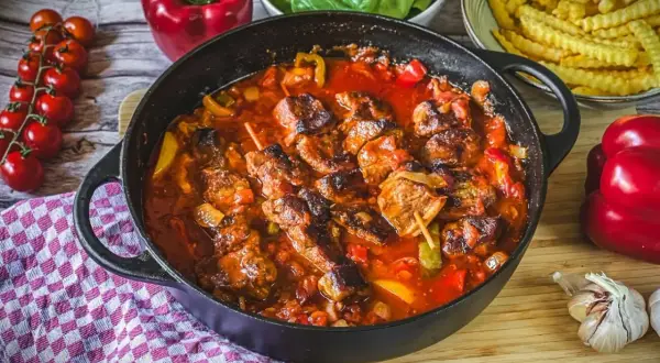 Herzhaftes Schaschlik im Backofen, geschmort in einer würzigen Tomatensoße mit Paprika und Zwiebeln. Dazu passen Pommes und frischer Salat.