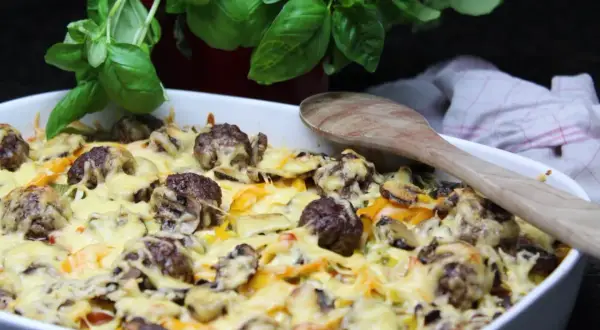 Herzhafte Fleischbällchen mit geschmolzenem Käse und Gemüse in einer Auflaufform. Ein köstliches Beispiel für Auflauf Rezepte mit Fleisch.