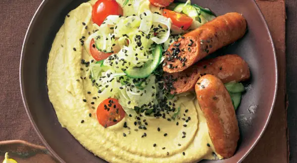 Hummus mit gegrillten Merguez-Würstchen, Tomaten, Gurken und schwarzem Sesam. Ein einfaches Merguez Rezept für Genießer.
