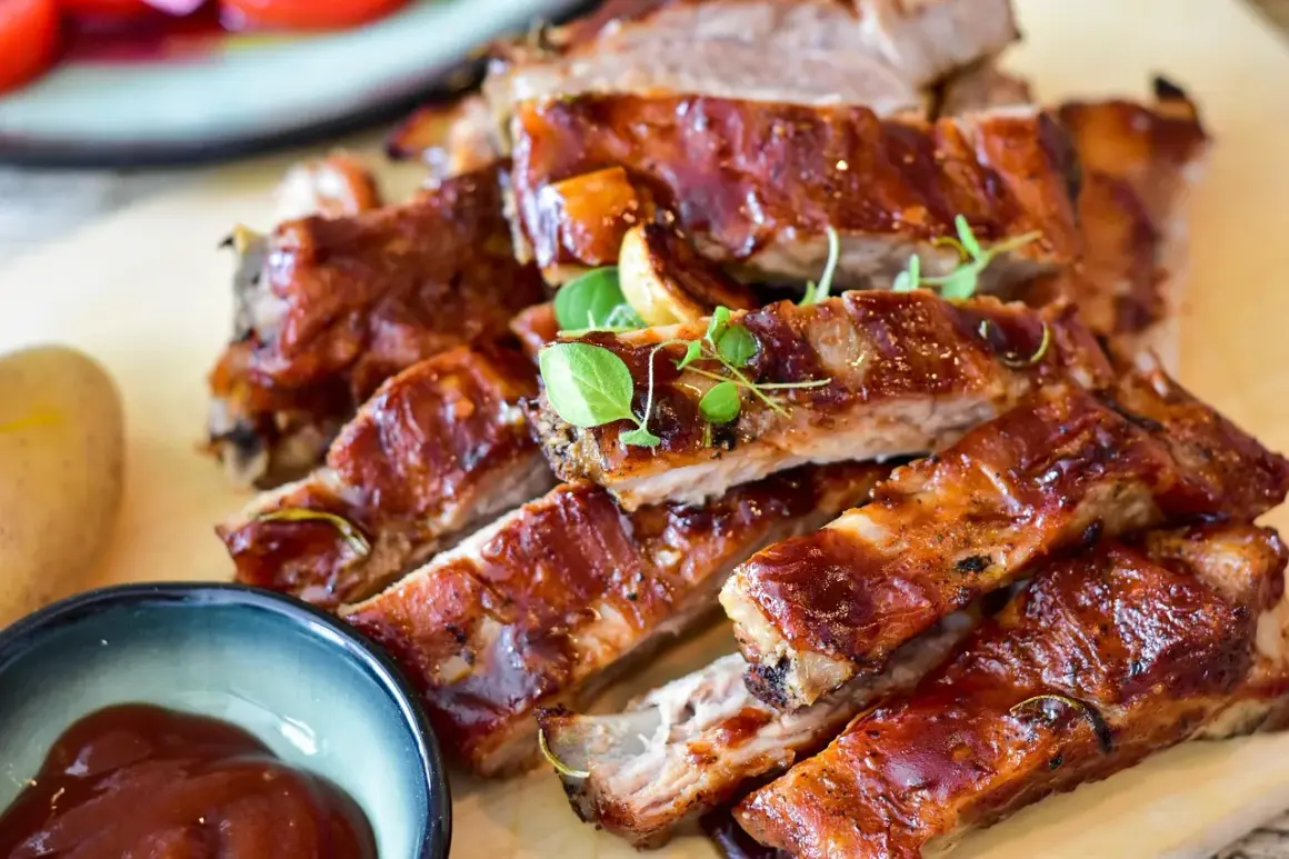 Saftige spareribs im backofen umluft: wie lange sie perfekt garen, zeigt dieses Bild. Dazu gibt es BBQ-Sauce und Kartoffeln.