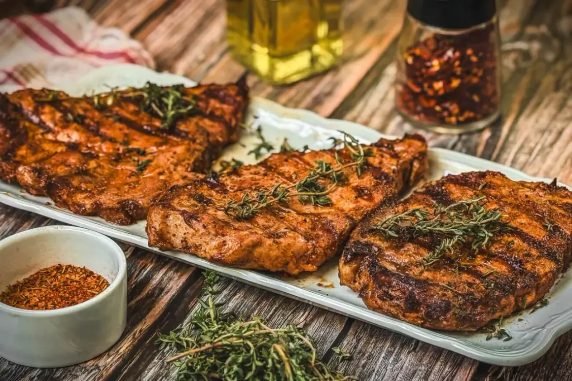Saftige Nackensteaks vom Grill, garniert mit frischem Thymian. Daneben eine Schale Gewürzmischung und ein Glas Chiliflocken.