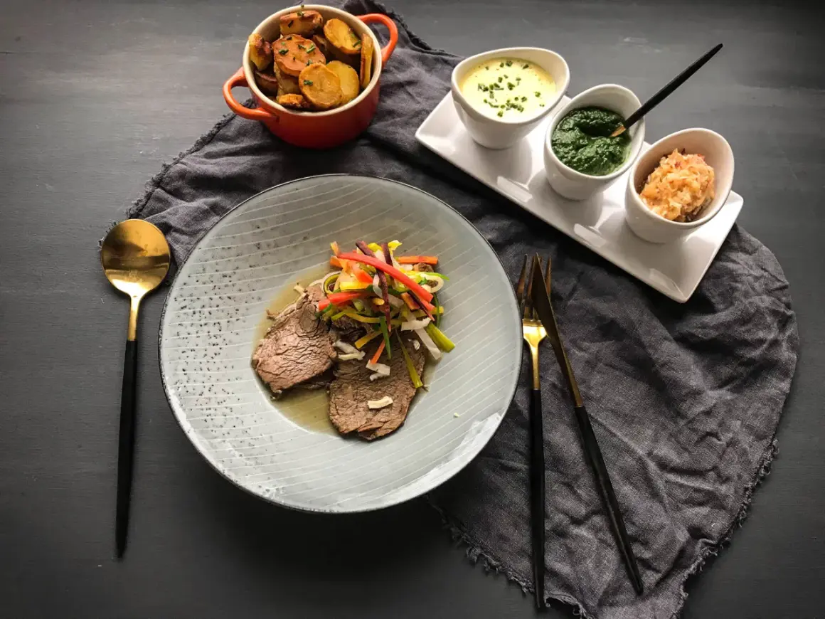 Ein köstliches Tafelspitz-Rezept mit zartem Rindfleisch, bunten Gemüsestreifen, Bratkartoffeln und drei Saucen.