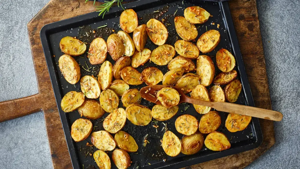 Goldbraune, knusprige Kartoffelspalten mit Rosmarin und Knoblauch, bereit für ein köstliches Ofenkartoffeln Rezept.