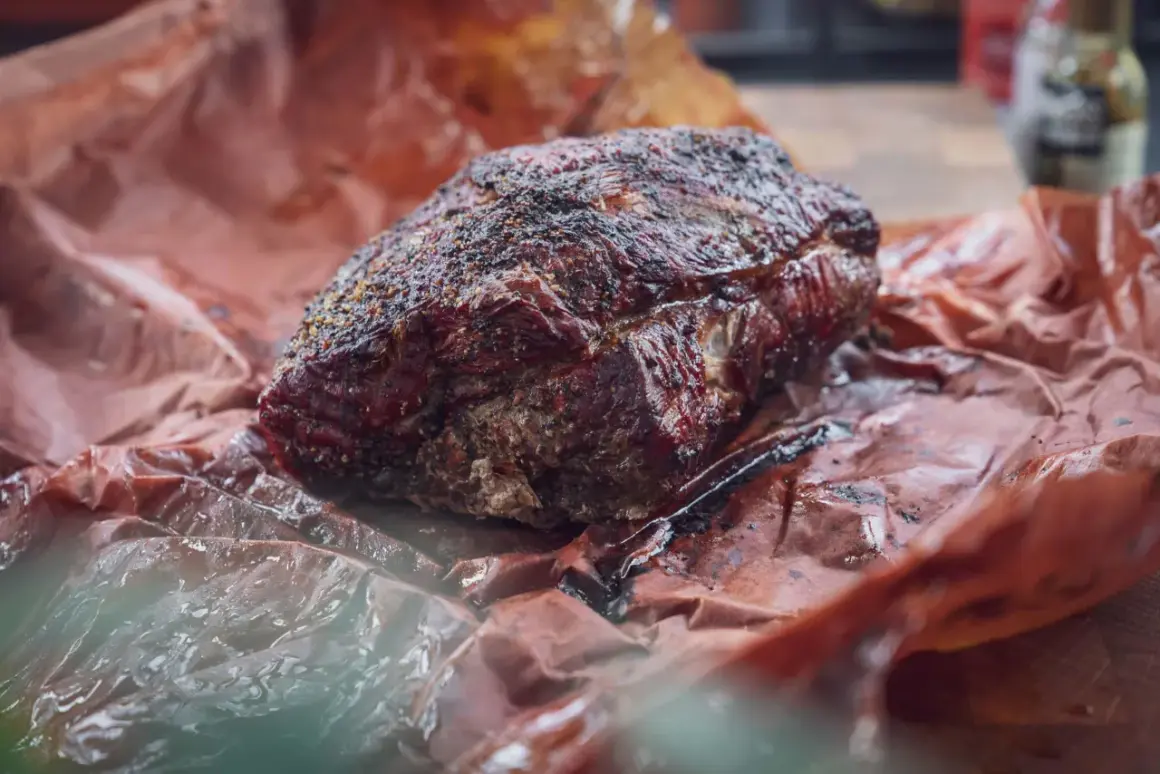 Saftiges, langsam gegartes Pulled Pork im Texas-Style, umhüllt von rauchiger Kruste und Gewürzen, ruht auf Butcher Paper.