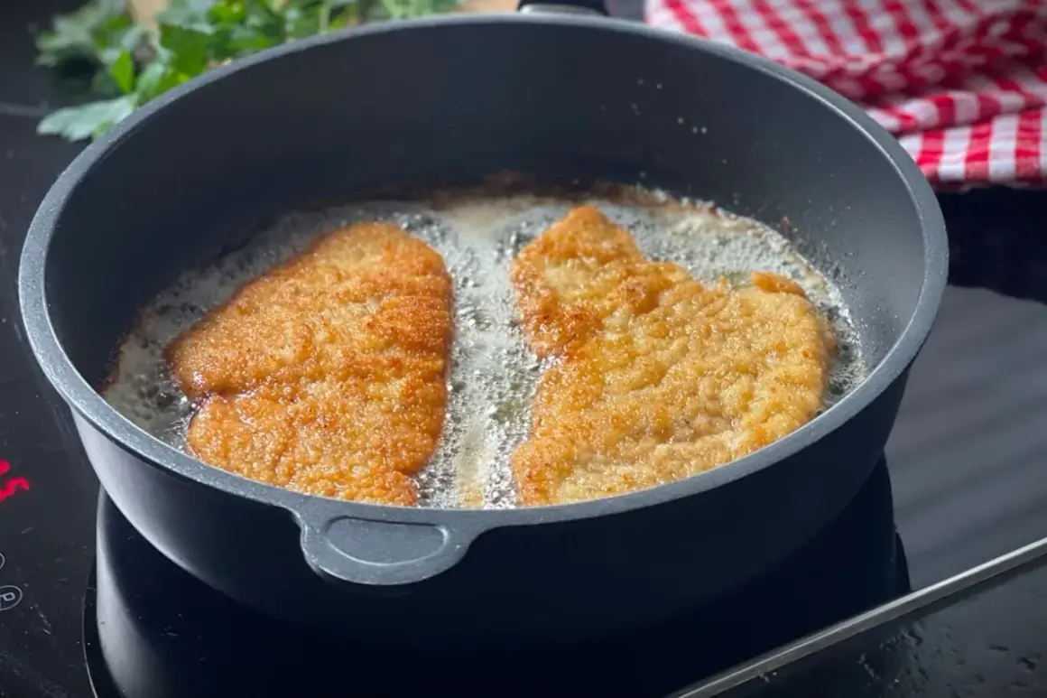 Zwei panierte Schnitzel braten in heißem Öl. Die goldbraune Kruste verspricht ein perfektes Ergebnis.