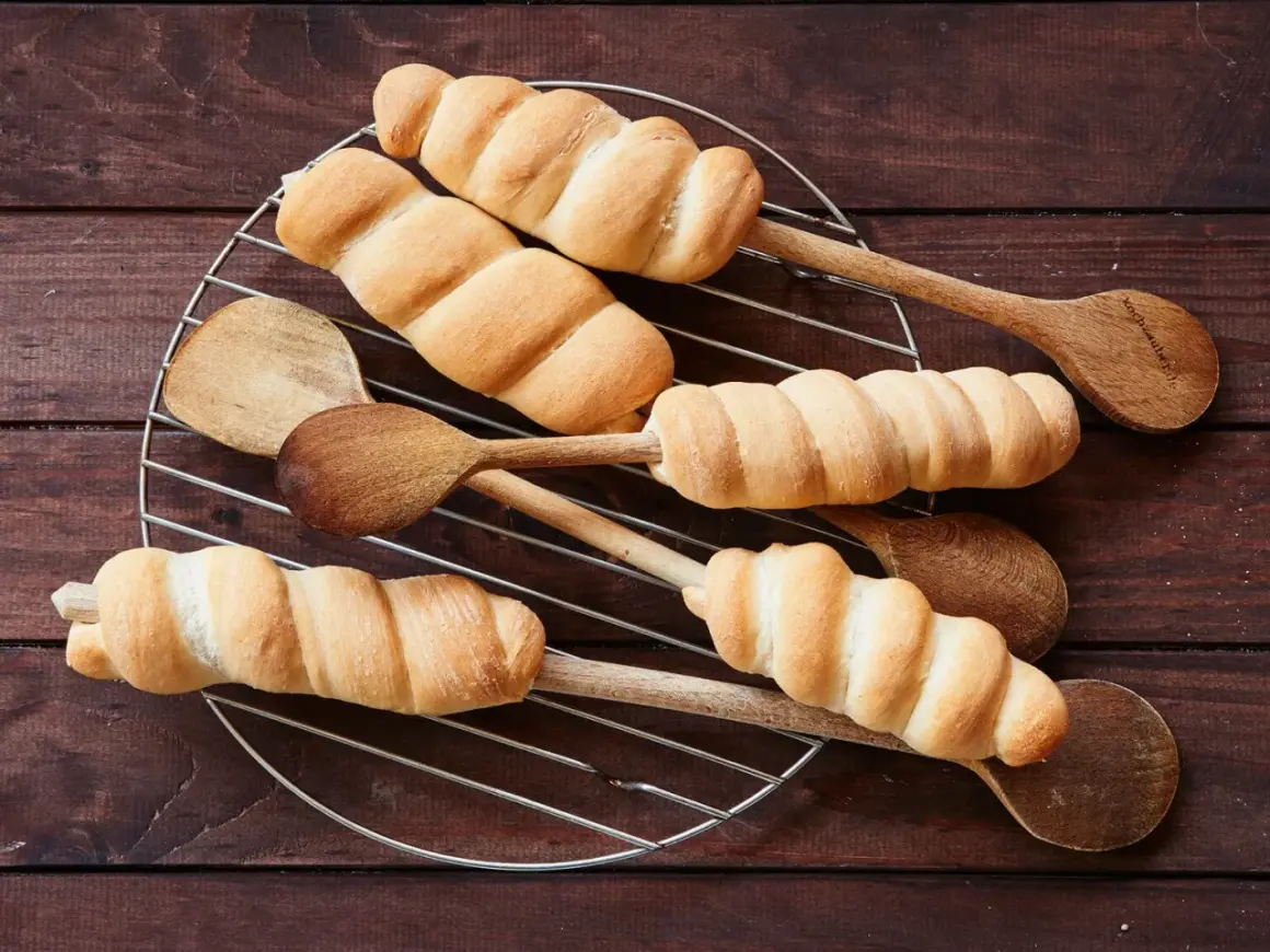 Goldbraunes Stockbrot-Rezept: Teig um Holzstäbchen gewickelt, auf einem Gitter abkühlen. Perfekt für Lagerfeuer!