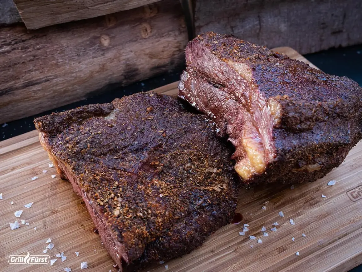Zwei saftige Brisket-Stücke auf einem Holzbrett, bereit für die Messung der Kerntemperatur. Perfekt gegrillt!