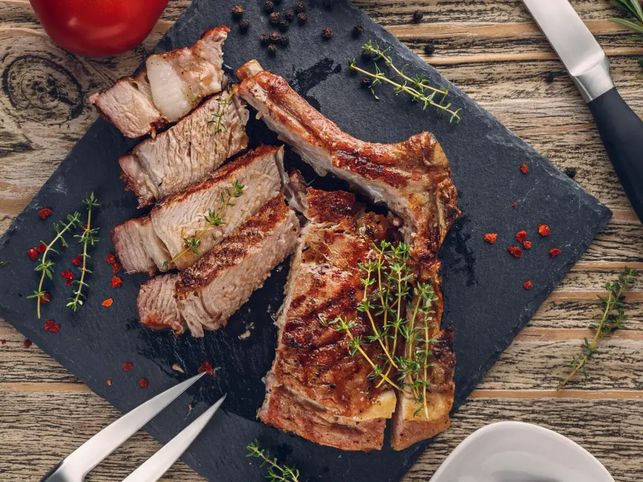 Saftiges Kalbskotelett, perfekt gegrillt. Die Kerntemperatur ist ideal für zartes Fleisch. Garniert mit frischem Thymian.