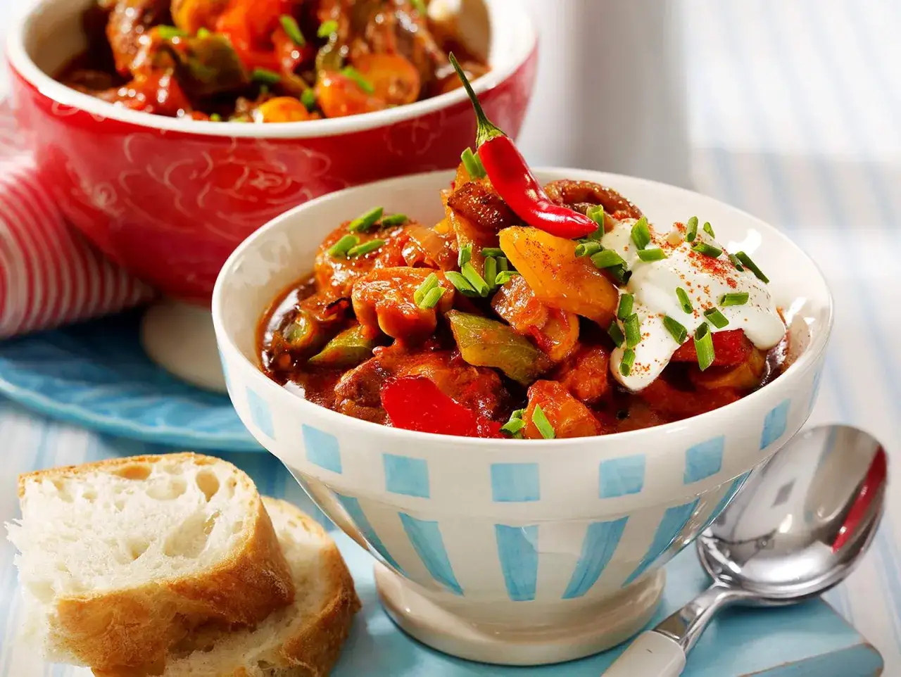 Herzhaftes Gulasch mit Paprika, garniert mit Sauerrahm und Chili. Ein perfektes Gulasch Rezept für kalte Tage. Dazu frisches Brot.