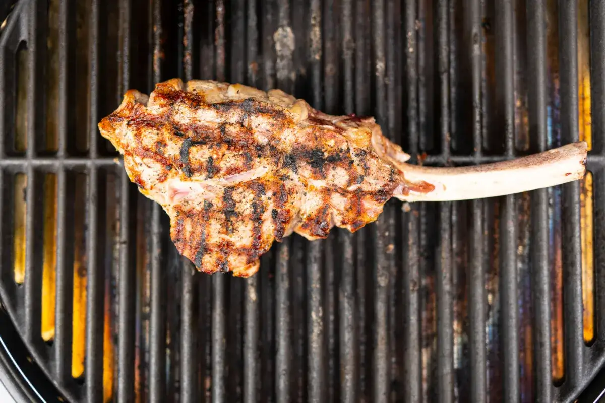 Ein saftiges Kalbskotelett mit Grillstreifen auf einem heißen Rost. Die Kerntemperatur ist entscheidend für perfekten Genuss.