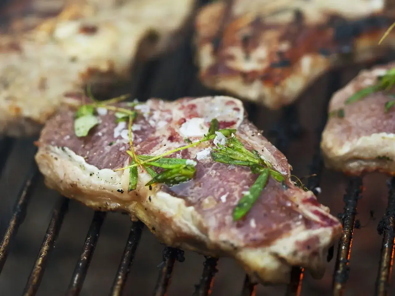 Saftige Lammkoteletts mit Kr&auml;utern und grobem Salz werden auf dem Grill zubereitet. Ein Genuss f&uuml;r jeden Grillmeister!