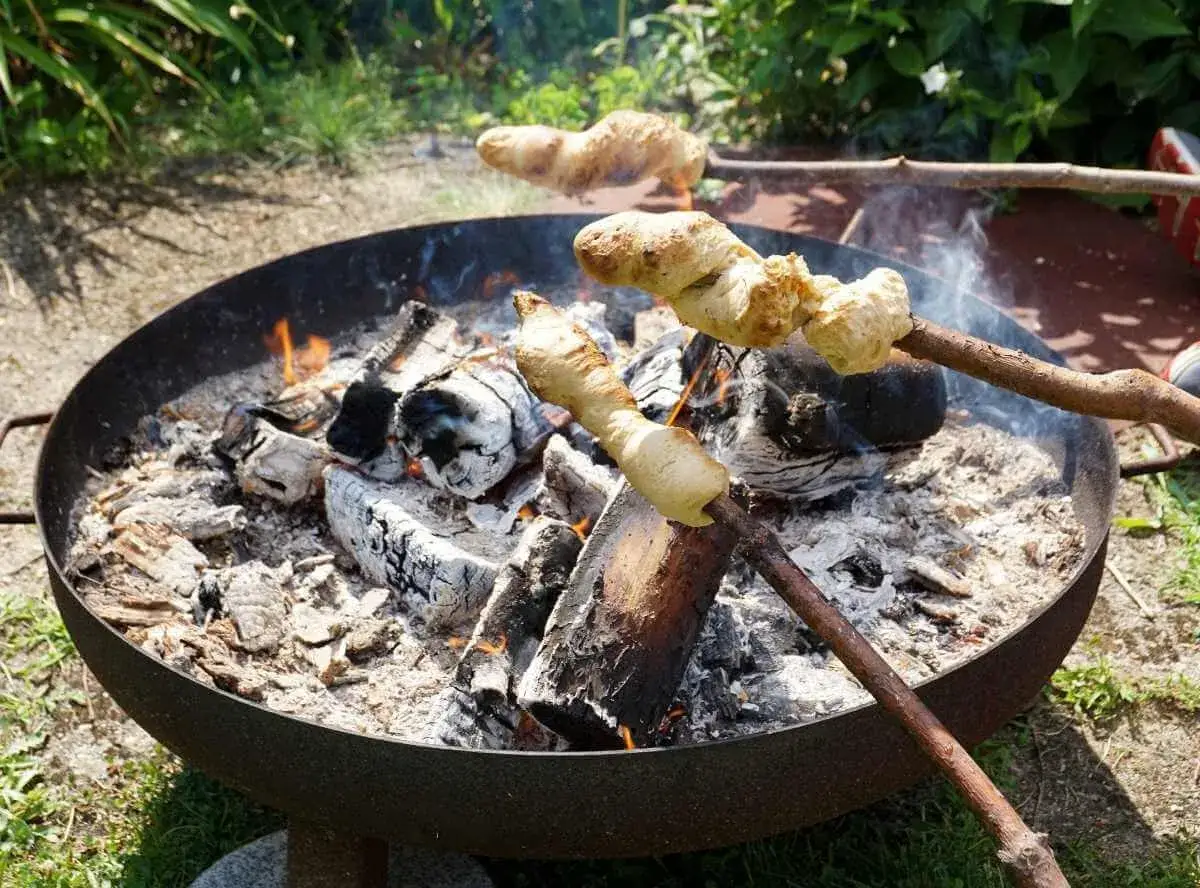 Stockbrot rezept: Teig wird &uuml;ber einem Lagerfeuer auf St&ouml;cken gebacken. Ein Klassiker f&uuml;r drau&szlig;en.