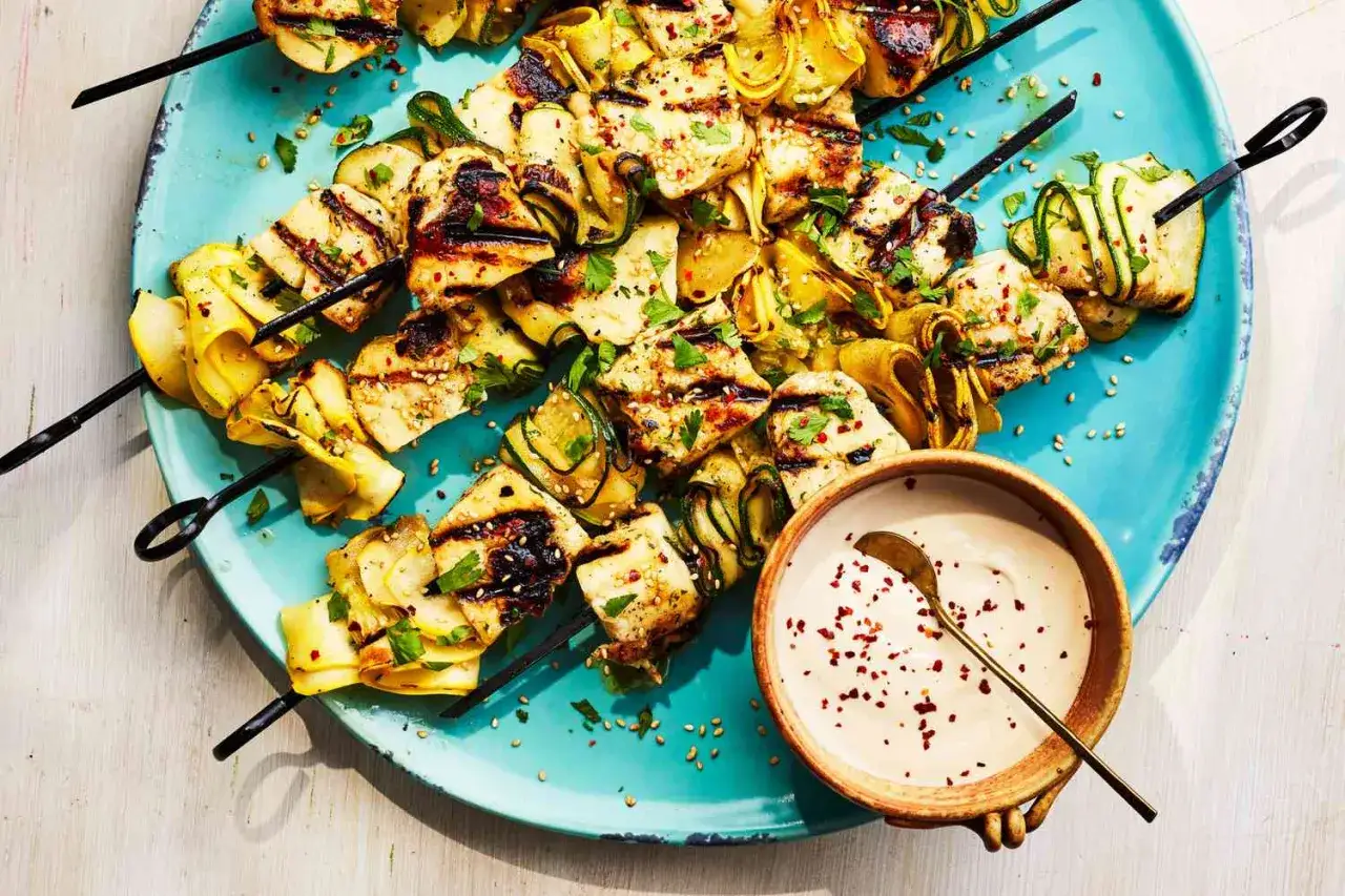 Gegrillte Hähnchen- und Zucchinispiesse mit Kräutern und Sesam, dazu eine cremige Dip-Sauce. Perfekt als schnelle Beilagen zum Grillen.