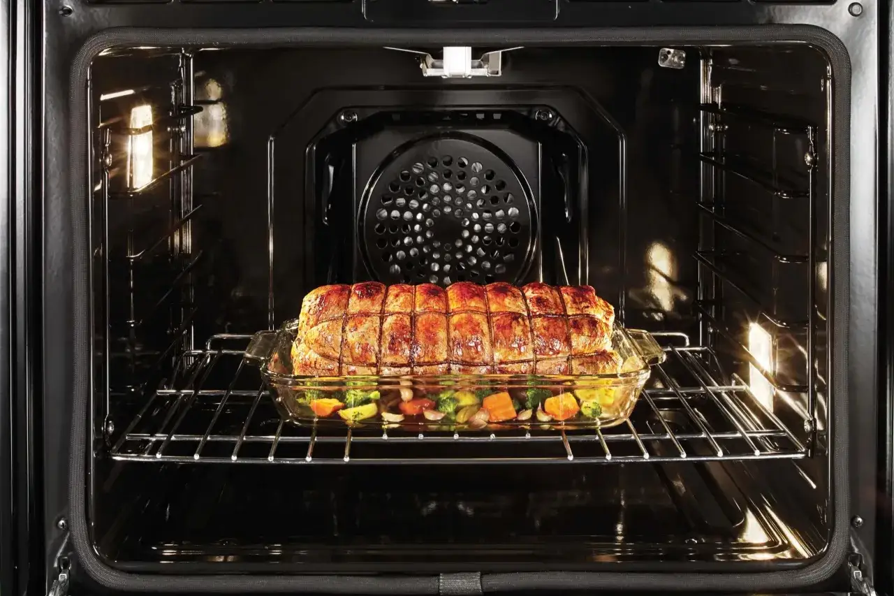 Ein Braten mit Gemüse gart in einem Glasbehälter im Ofen. Perfekt für niedertemperatur garen für zartes Fleisch und saftiges Gemüse.