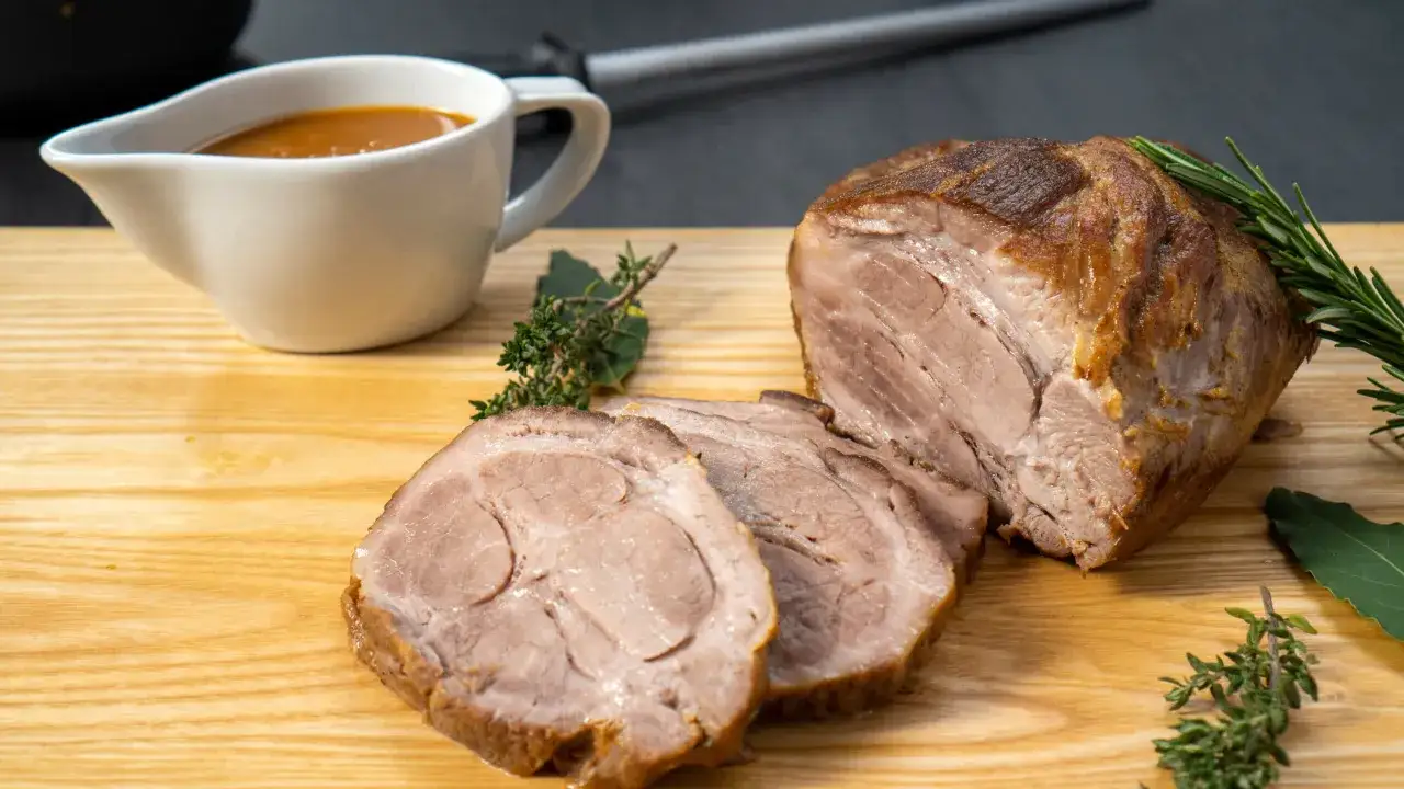 Saftiger schweinelummer, aufgeschnitten und mit Kr&auml;utern und So&szlig;e serviert. Ein Genuss f&uuml;r jeden Gaumen.