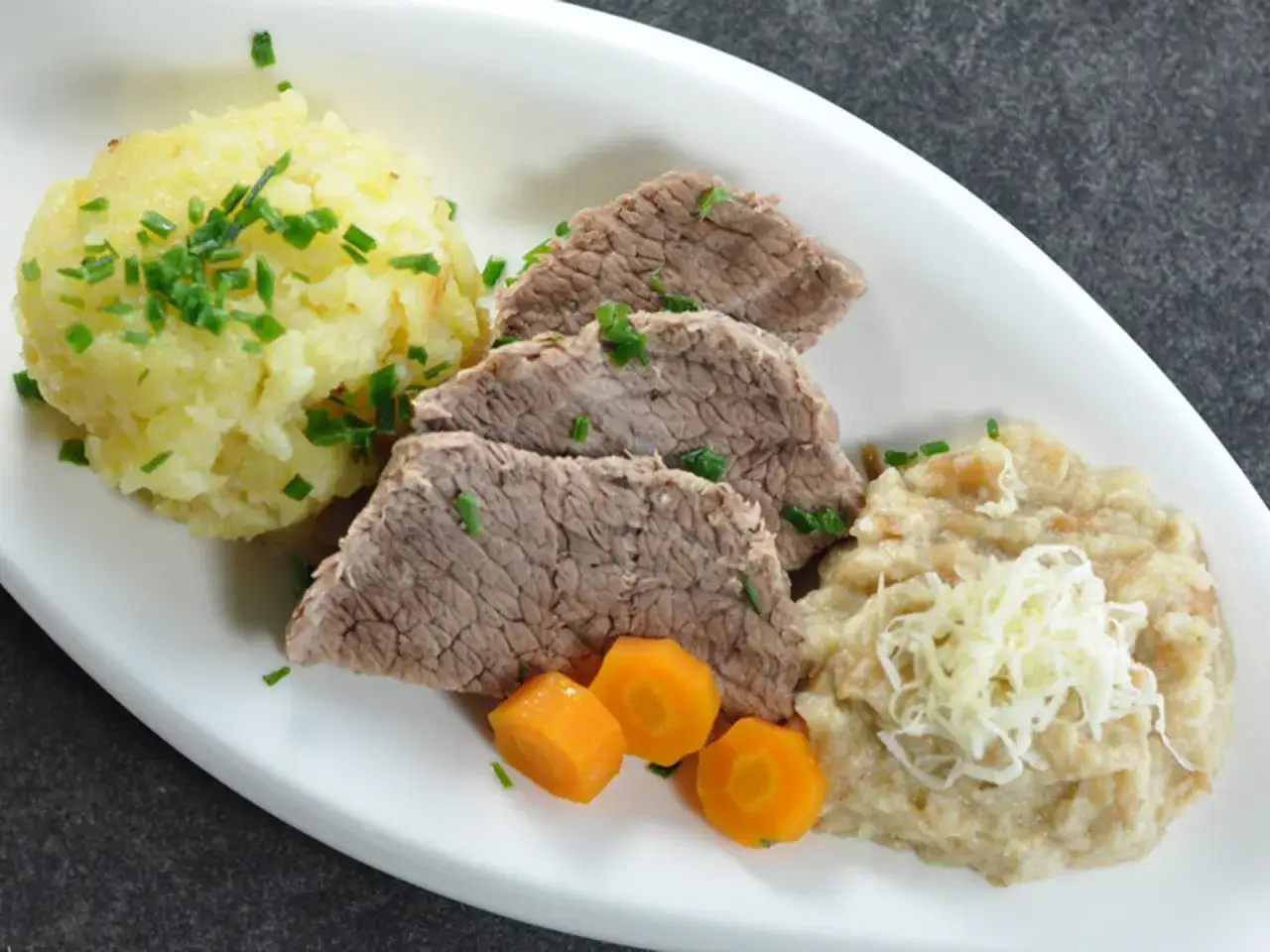 Zartes Tafelspitz-Rezept mit Kartoffelpüree, Apfelkren und Karotten. Ein Klassiker der österreichischen Küche.