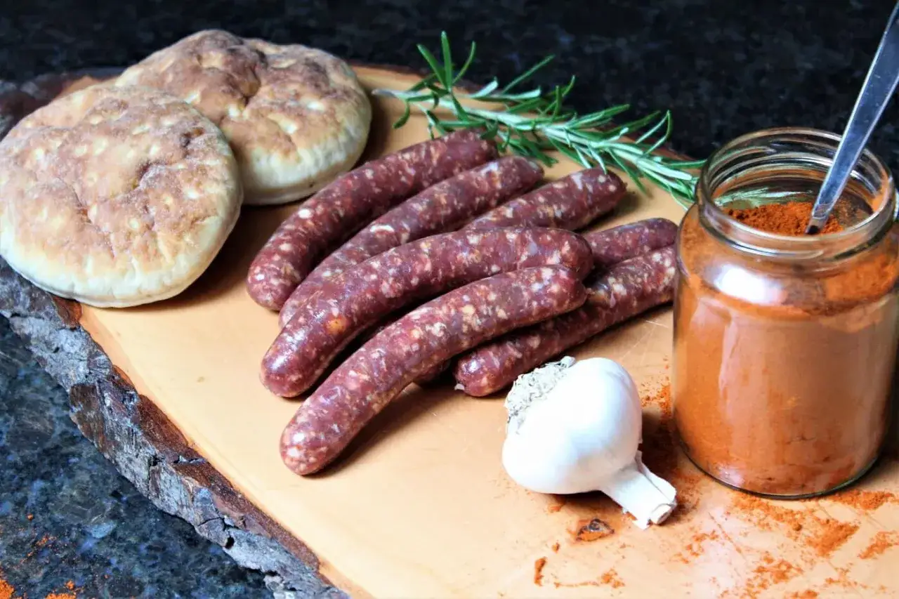 Merguez-Würstchen, Brot, Knoblauch und Gewürze – alles bereit für ein köstliches Merguez-Rezept.