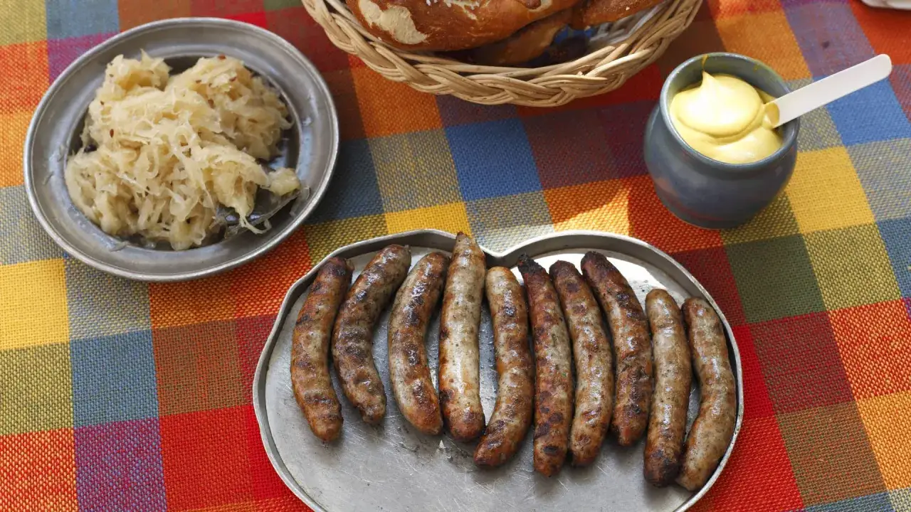 Bratwurst und Rostbratwurst: eine Auswahl gebratener Würste mit Sauerkraut, Senf und Brezeln.