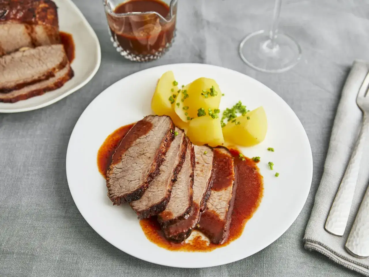 Saftiges Braten Fleisch mit Kartoffeln und Sauce auf einem Teller.