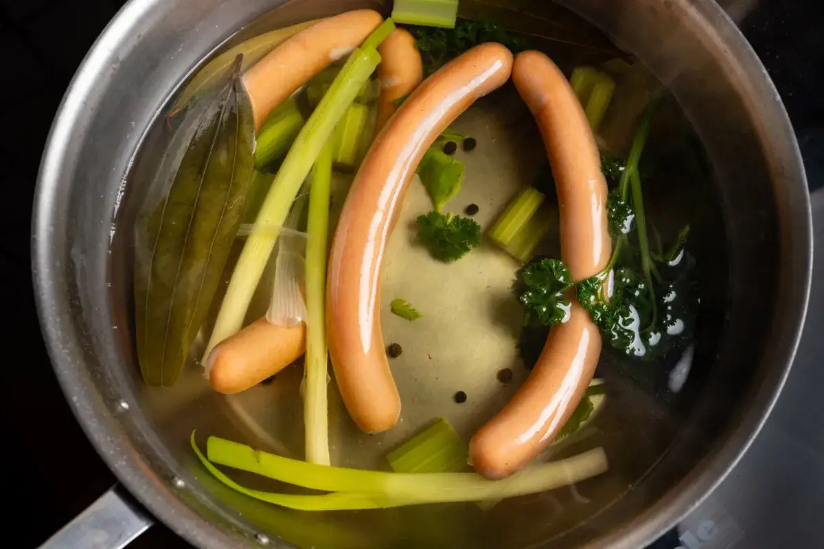 Würstchen kochen wie lange? In einem Topf mit Wasser, Sellerie, Lorbeerblatt und Petersilie garen die Würstchen.