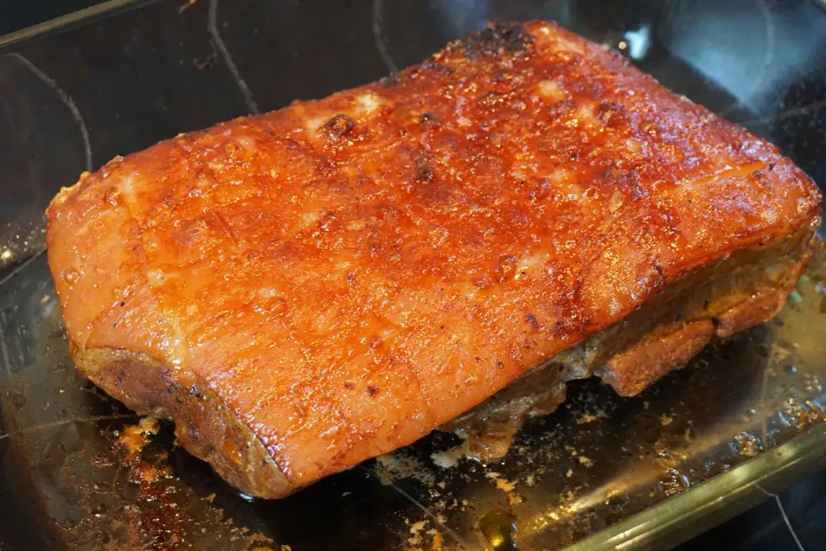Saftiger Schweinebraten sous vide mit knuspriger Kruste in einer Glasschale.