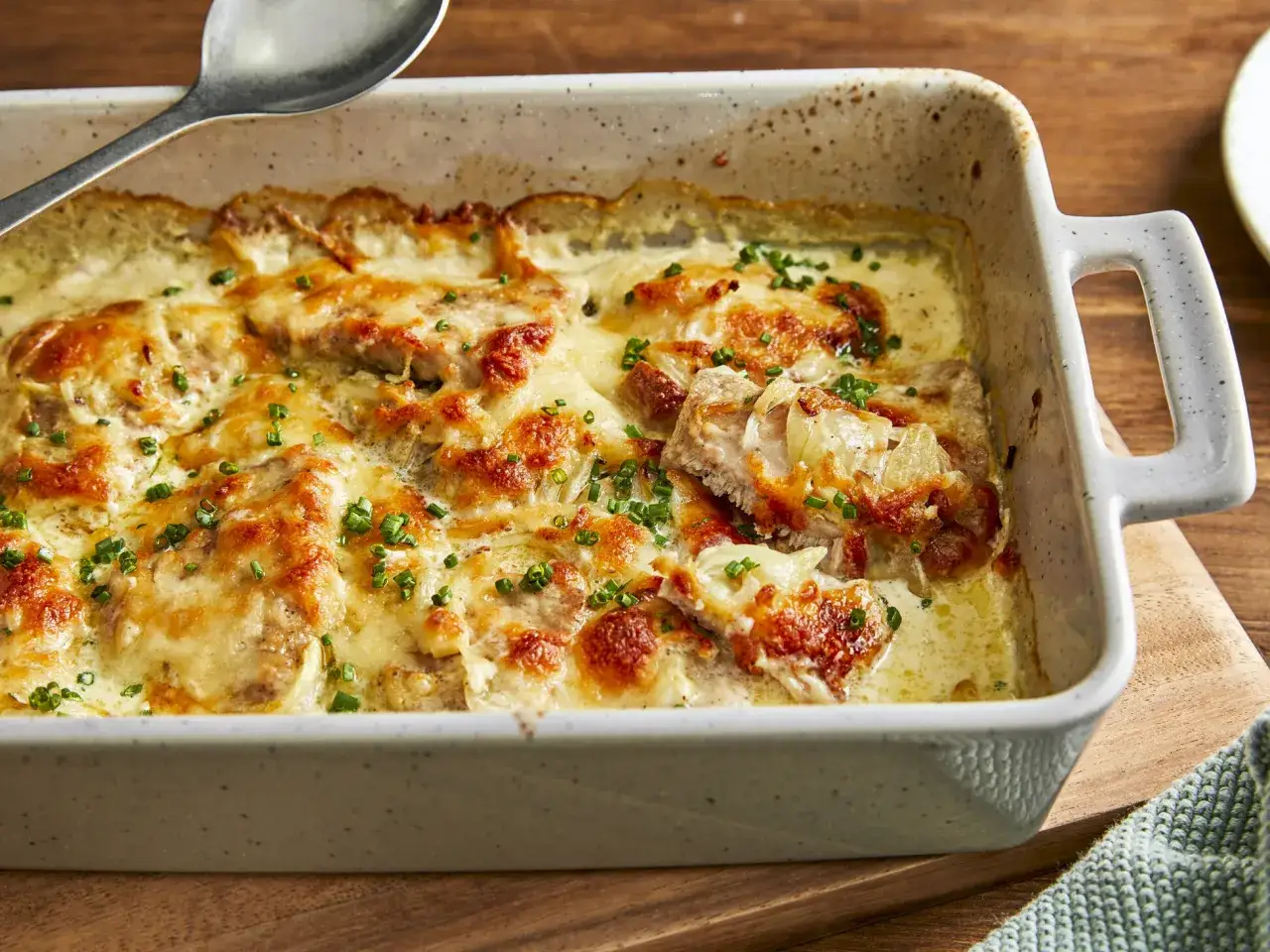 Zwiebel Sahne Schnitzel in einer Auflaufform, überbacken mit Käse und garniert mit Schnittlauch.