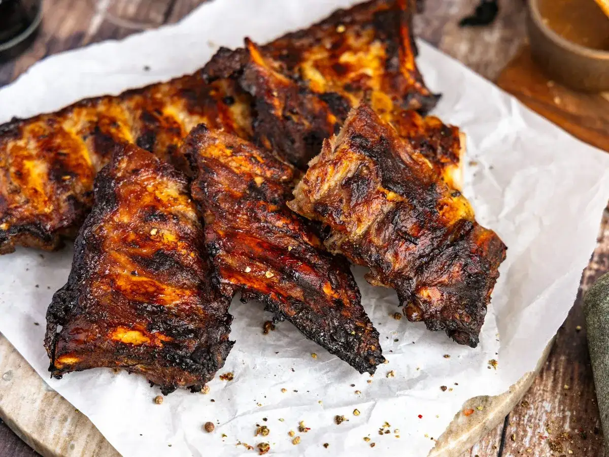 Saftige Rippchen, perfekt mariniert und gegrillt, liegen auf Backpapier. Ein Genuss für alle, die Rippchen marinieren lieben.