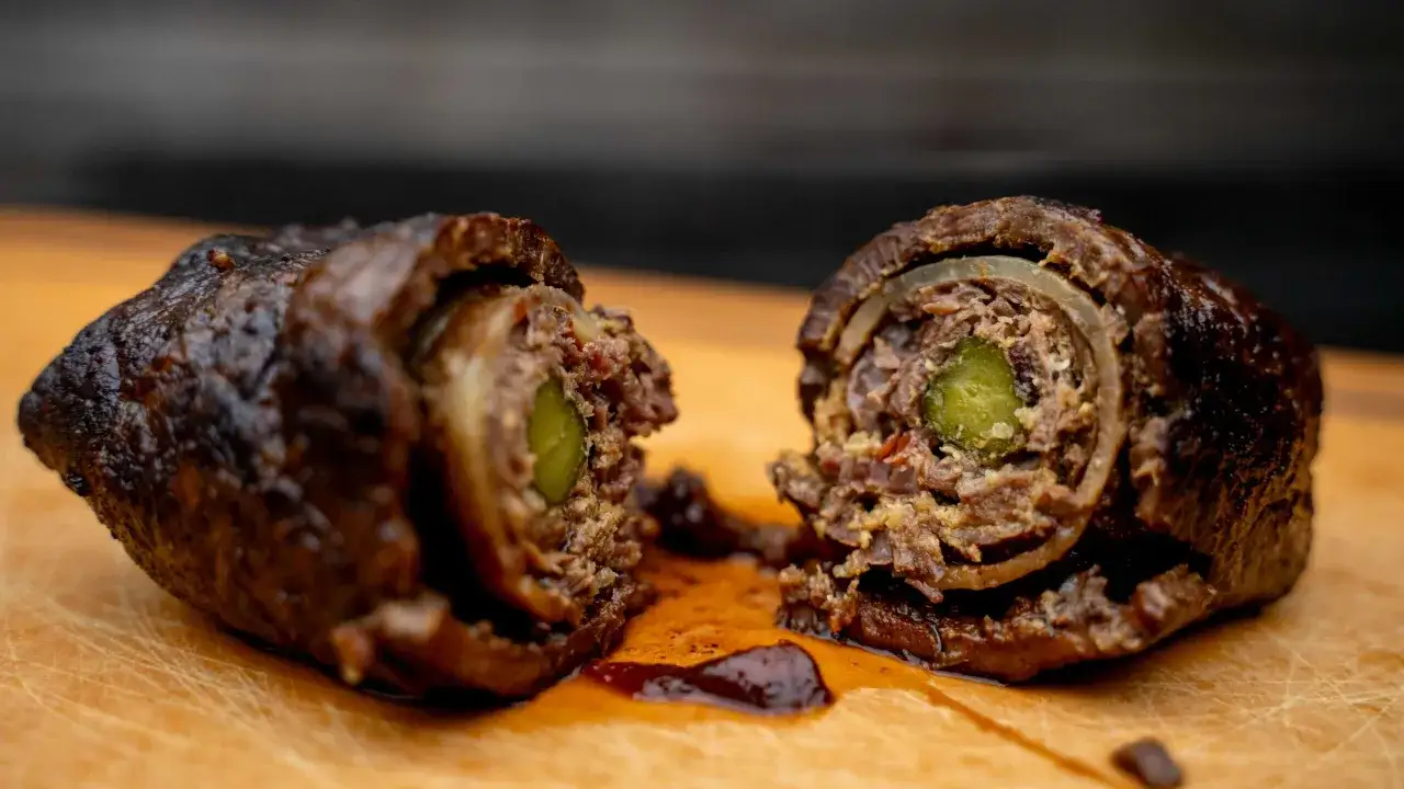 Zwei saftige Rouladen, im Dutch Oven geschmort, zeigen ihre köstliche Füllung aus Gurke und Zwiebeln.