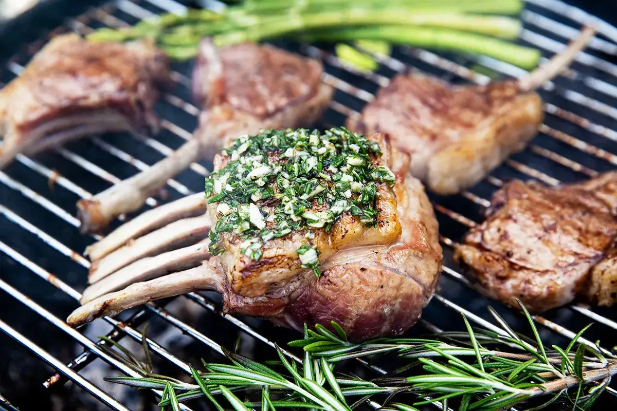 Saftiges Lammkarree grillen, mit Kräutern und Knoblauch belegt, daneben Spargel und Rosmarin. Ein Fest für die Sinne!