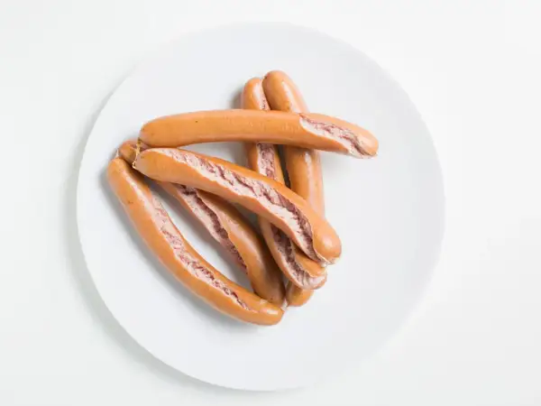 Ein Haufen gekochter Würstchen auf einem Teller. Wie lange wurst kochen?