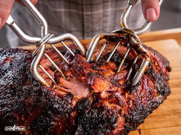 Saftiges Pulled Pork, perfekt für deine Smoker Rezepte. Mit zwei Fleischgabeln wird das zarte Fleisch auseinandergezogen.