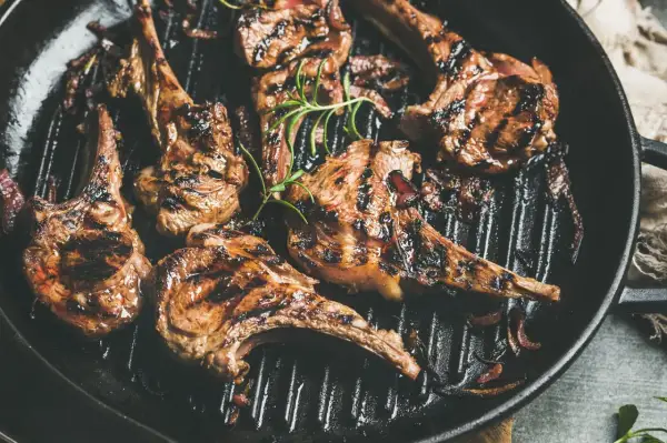 Saftiges Lammfilet grillen in einer Pfanne mit Rosmarin und Zwiebeln. Perfekt gegrillte Lammkoteletts mit köstlichen Röstaromen.