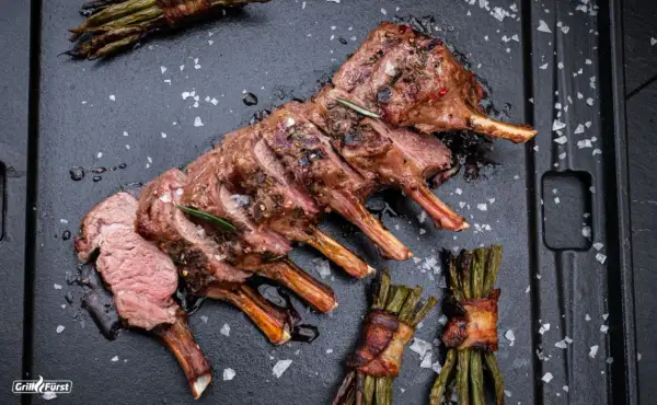 Perfekt gegrilltes Lammkarree mit Rosmarin und Speck-umwickeltem Spargel. Ein Fest für die Sinne beim Lamm grillen.