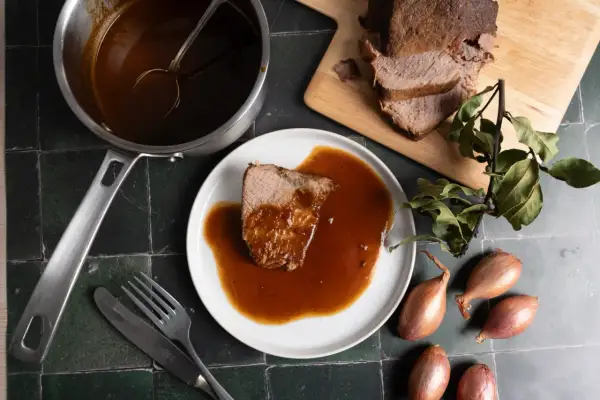 Zarter Rinderbraten im Backofen, serviert mit reichlich Sauce. Ein Festmahl, das auf dem Tisch wartet.