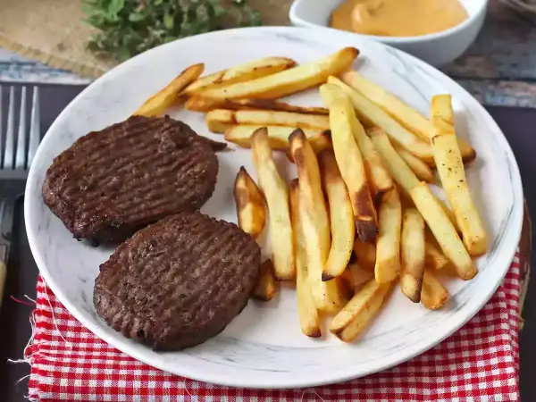 Zwei Hacksteaks mit Pommes Frites auf einem Teller. Ein einfaches Hacksteak rezept für einen schnellen Genuss.