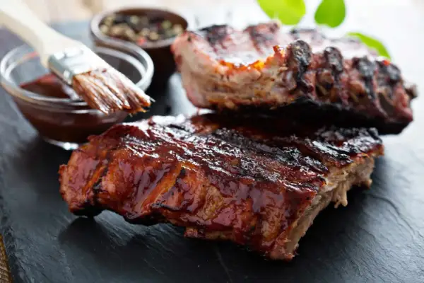 Saftige Spareribs mit glänzender BBQ-Sauce, bereit zum Servieren. Die Kerntemperatur ist perfekt für zartes Fleisch.